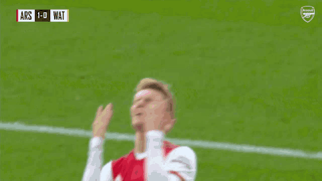 a soccer player in a red and white uniform with emirates fly better written on it