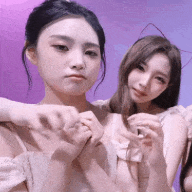 two girls are posing for a picture and one has a cat ear headband on her head