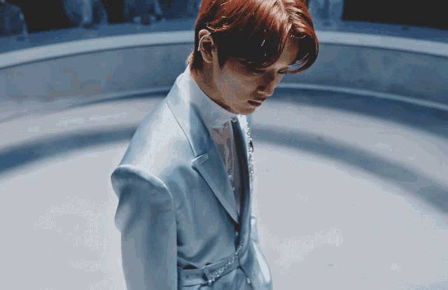 a man with red hair wearing a blue suit and white shirt