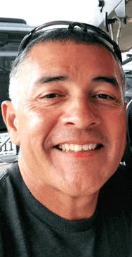 a man wearing sunglasses smiles for the camera