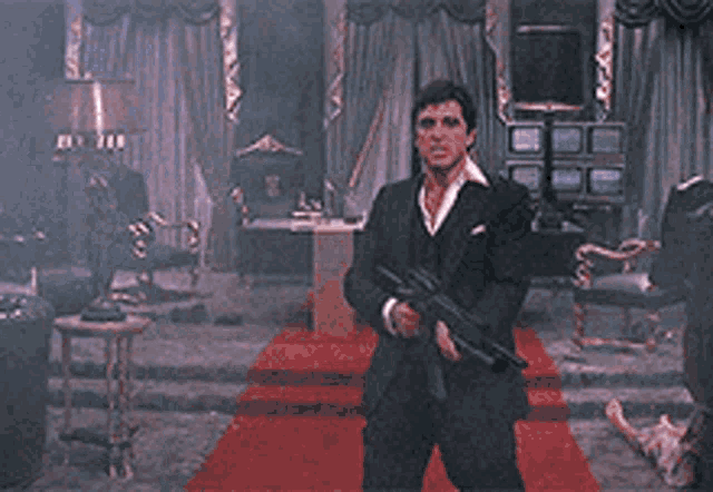 a man in a suit is shooting a gun in a room