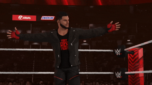 a wrestler with his arms outstretched in front of a snickers sign