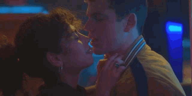 a man and a woman are kissing in a club .
