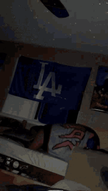 a person is laying in front of a la dodgers banner
