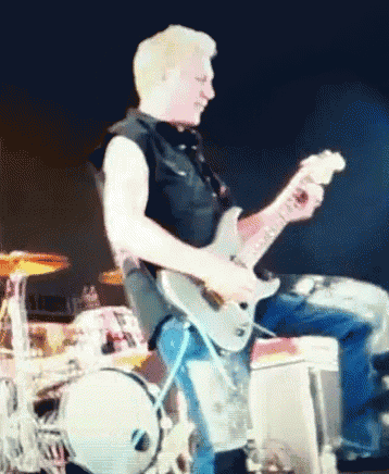 a man is playing a guitar on a stage