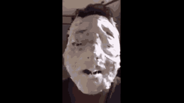 a man with a face covered in whipped cream .