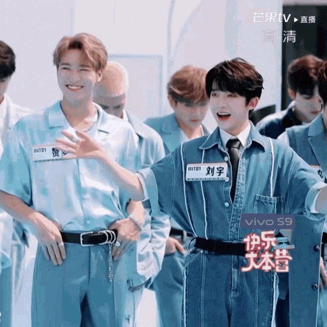 a group of young men are standing in front of a sign that says vivo