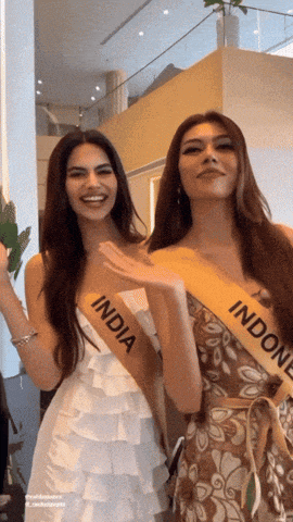 two women wearing sashes that say india and indonesia are standing next to each other