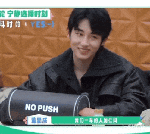 a man sitting in front of a sign that says " no push "