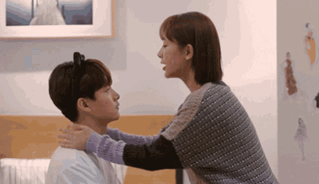 a woman in a purple sweater is kissing a man in a white shirt
