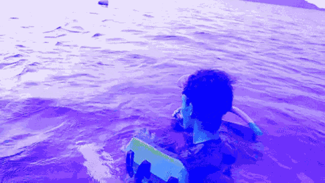 a person is swimming in a purple water