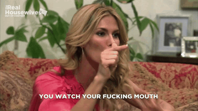 a woman sitting on a couch with her finger in her nose and the words you watch your fucking mouth