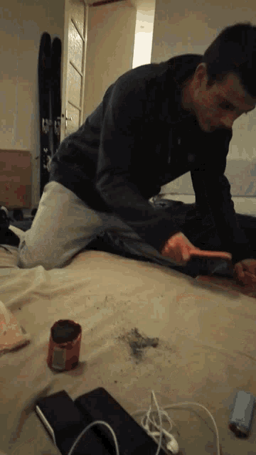 a man is kneeling on a bed with a remote control that says ' nintendo wii ' on it
