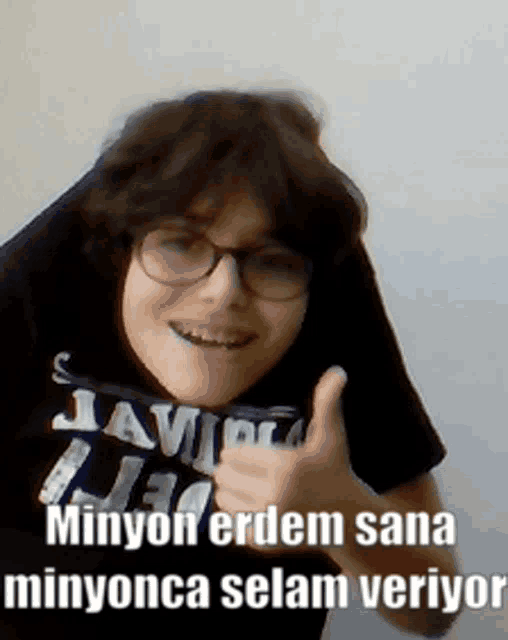 a boy wearing glasses giving a thumbs up with the words " minyon erdem sana minyonca selam veriyor "