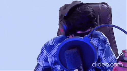 a man wearing headphones is sitting in a chair with a microphone .