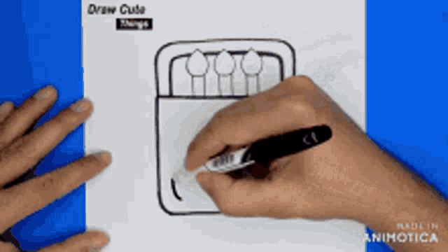 a person is drawing a box of pencils with a marker on a piece of paper