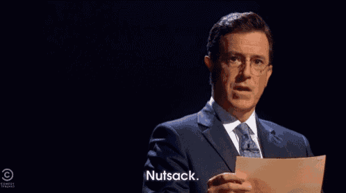 a man in a suit and tie is holding a piece of paper and saying " nutsack "