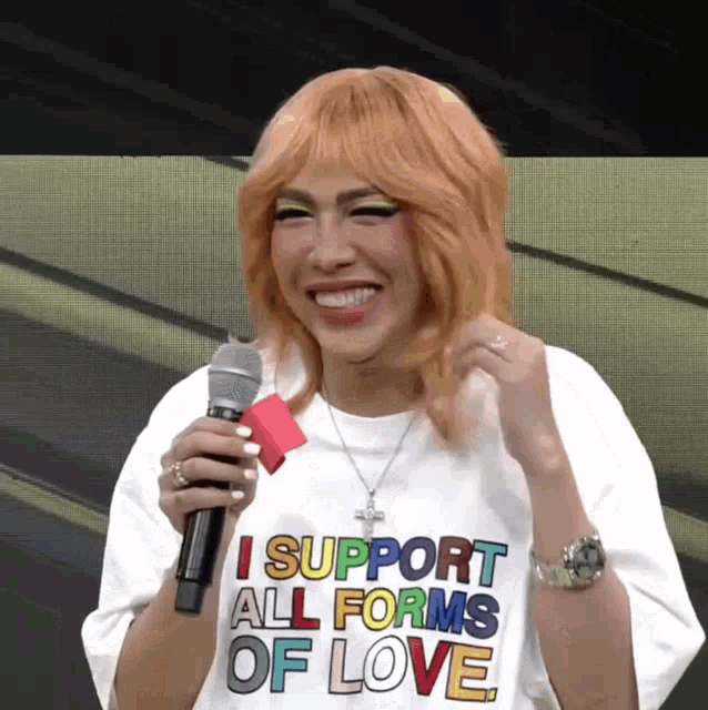 a woman wearing a shirt that says " i support all forms of love "