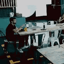 a man sitting at a table with a bottle of water on it