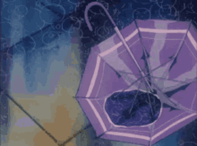 a purple umbrella is sitting on a tiled floor next to a puddle of water .