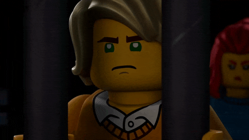 a lego man with a serious look on his face is behind bars