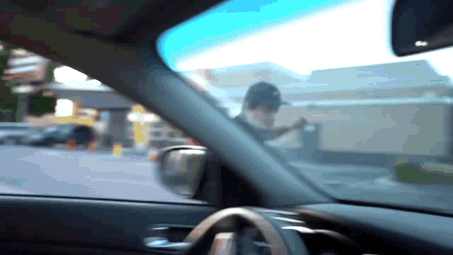 a blurry picture of a man in a hat standing in a parking lot