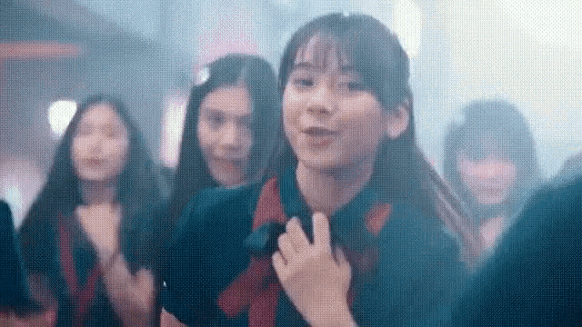 a group of girls are dancing in a dark room .