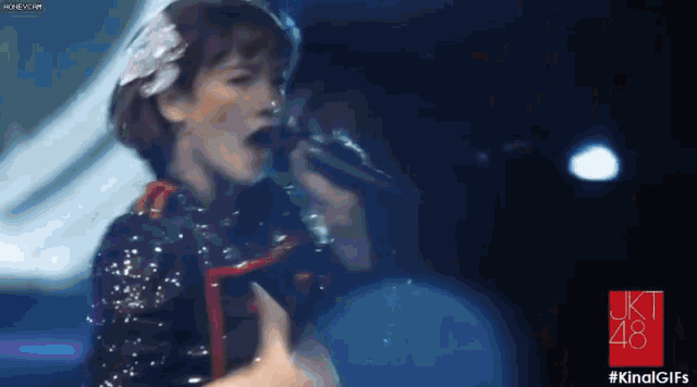 a woman singing into a microphone on a stage .