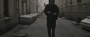 a man in a leather jacket smoking a cigarette on a city street