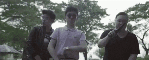a group of young men standing next to each other in a park .
