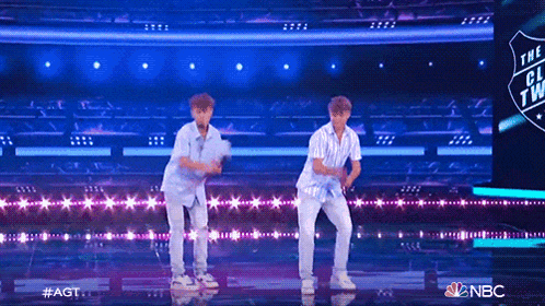 two young men are dancing on a stage in front of a screen that says nbc