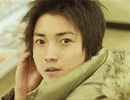 a close up of a person 's face with a green jacket on