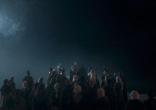 a group of people standing in front of a large dragon