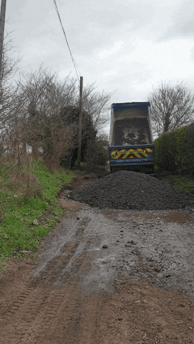 a muddy road with a truck that says ' lloyds truck ' on the back