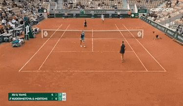 a woman is holding a tennis racquet on a tennis court in front of an oppo advertisement .