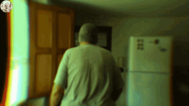 a blurred image of a man standing in front of a refrigerator that says ice
