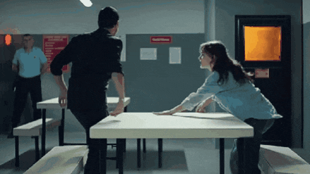 a man and a woman are standing at a table in a room