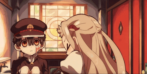 a boy and a girl are standing in front of a window