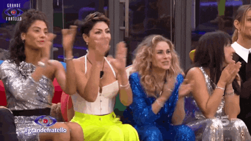 a group of women are sitting in front of a screen that says grande fratello on it