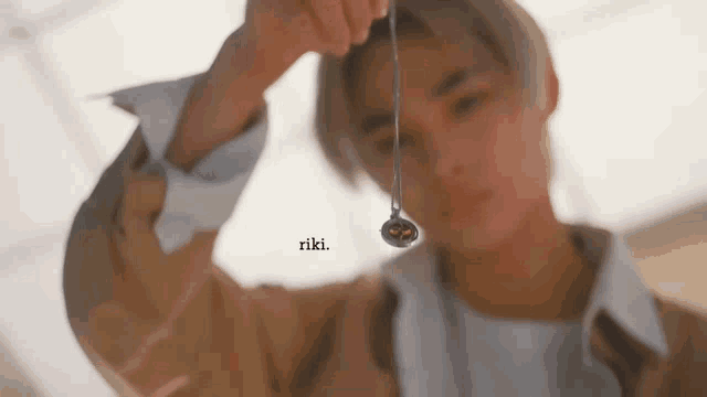a close up of a person holding a necklace in their hands .