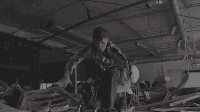 a man in a striped jacket is sitting on a motorcycle in a warehouse