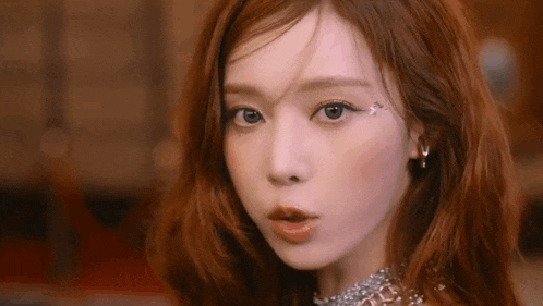 a close up of a woman 's face with red hair .