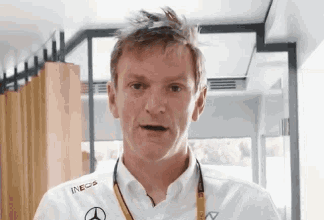 a man wearing a white shirt that says ineos