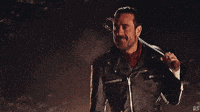 a man in a leather jacket is holding a knife in his right hand