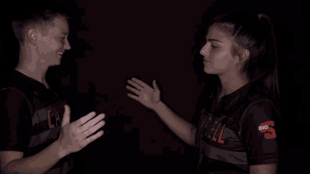 a man and a woman are giving each other a high five and the woman is wearing a shirt with the number 5 on it