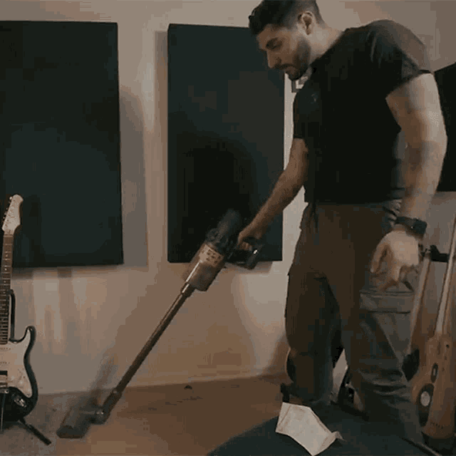 a man is using a vacuum cleaner to clean the floor