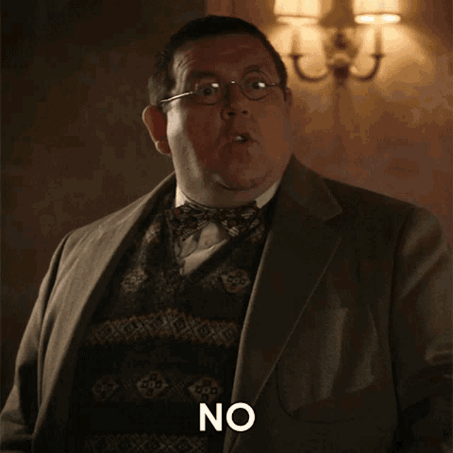 a man in a suit and bow tie with the word no on his chest