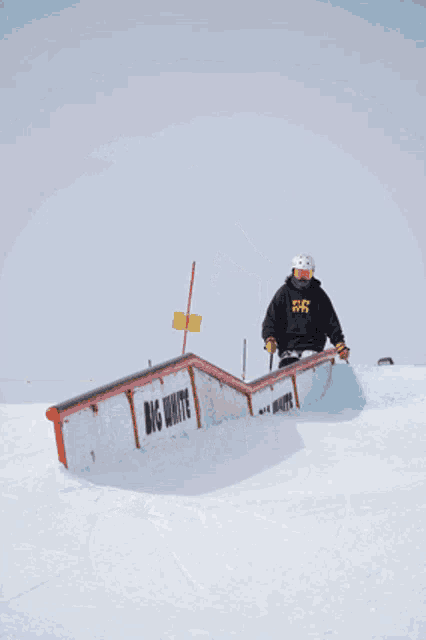 a skier is doing a trick on a big white railing