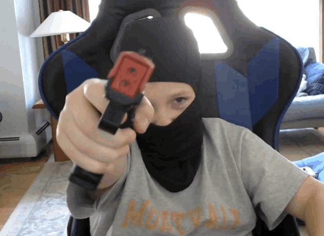 a person wearing a mask and a shirt that says mortal kombat