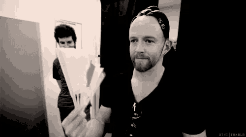 a man with a beard is holding a piece of paper and smiling .
